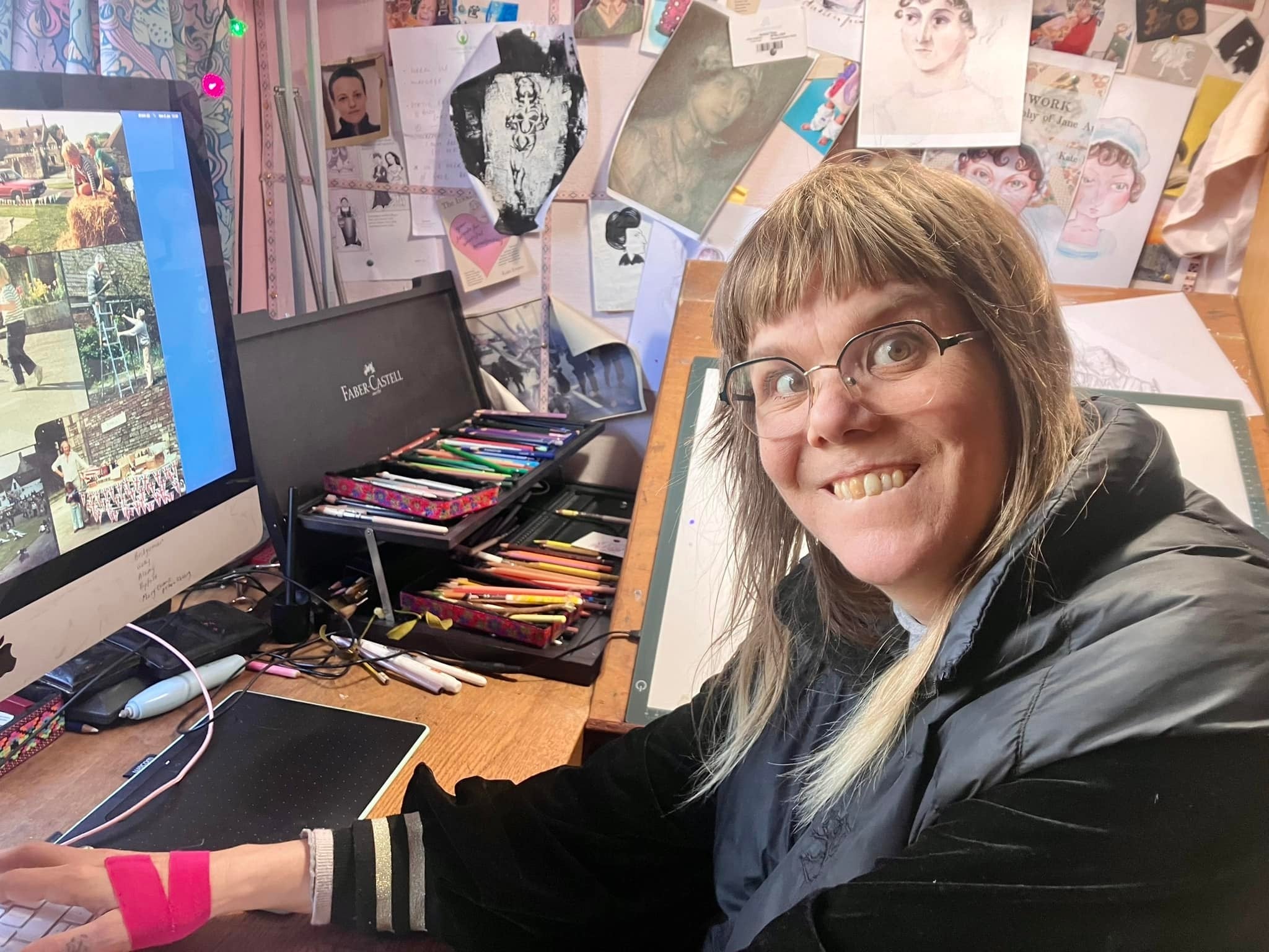 Photo of cartoonist and author Kate Evans working at her desk